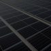 Rows of solar panels mounted on a large commercial roof