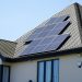 Solar panels mounted above the tiles on a pitched house roof